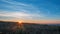 The first rays of the rising sun in a field on the outskirts of the city