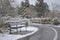 The first snow. Abandoned bench and a road