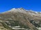 First snow on the rocky mountain peak Piz Champatsch (2946 m) in the Swiss Alps and above the mountain road pass Fluela