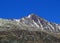 First snow on the rocky mountain peak Piz Champatsch (2946 m) in the Swiss Alps and above the mountain road pass Fluela