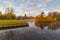 First sun illuminates the autumn leaves above misty lake.