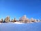 First sunbeams of day on hill in winter wonderland scenery under cloudless deep blue sky