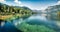 First sunlight glowing surface of Bohinj lake. Spectacular summer panorama of Triglav national park. Great morning view of Julian