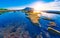 First sunrays at sunrise at Ilchulbong volcano crater with view over ocean and green moss stones , Jeju Island, South Korea