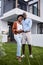 First-time homeowners and parents. Portrait of a young couple standing outside their new home.