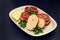 Fish balls with lemon on dish on black ceramic background