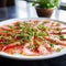Fish Carpaccio with herbs on plate