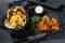 Fish and chips, French fries and cod fillet fried in breadcrumbs. Black background. Top view