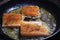 Fish fillet steaks frying on a skillet