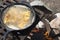 Fish frying in a cast iron pan on an outdoor grill