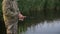 Fish-man fishing over the lake in the spring. Solitary angler staying alone surrounded by nature. He has a rest.