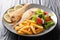 Fish menu fried pink dorado with french fries, lemon and vegetable salad close-up on a plate. horizontal