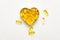 Fish oil capsules in a heart shape boxes on white background, vitamin D supplement, health care concept, top view