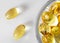 Fish oil capsules omega-3 in a glass bowl. Close-up, white background. Flat lay, nutritional supplements