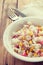 Fish salad on white bowl on brown background