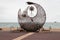 A fish sculpture on a beach filled with plastic bottles to encourage recycling and