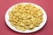 Fish-shaped cookies in a white plate on a crimson background