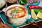 Fish soup with salmon and shrimps, dill, potatoes, lemon, peppers and bread on dark wooden background,