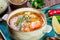 Fish soup with salmon and shrimps, dill, potatoes, lemon, peppers and bread on dark wooden background,