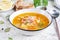 Fish soup with salmon, vegetables and rice in white bowl.