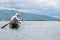 Fisheerman fishing ans sitting on small wooden boat on inle lake in myanmar