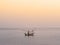 Fisher boat floating on the sea with golden sky in the morning