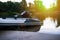 Fisher inflatable motor boat on the sandy river bank at the dusk s