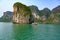 Fisherboat in Ha Long Bay  Vietnam. Small colorful boat in front of overgrown bizarre shaped rock formations in South China Sea  V