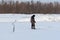 A fisherman alone catches fish on ice in a winter, frosty day