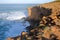 A fisherman angling above the high cliffs near Amoreira beach Aljezur, Costa Vicentina, Algarve