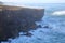 A fisherman angling above the high cliffs near Amoreira beach Aljezur, Costa Vicentina, Algarve