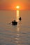 Fisherman on beautiful calm bay at sunrise