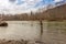 A fisherman with a big fish on the line in a spring river in Canada