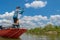 Fisherman on boat make a cast by fishing rod at wild river