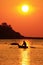 Fisherman on the boat over dramatic sunset