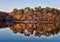 Fisherman on Calm Lake by Home in Autumn