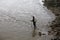 A fisherman carrying bag with a bamboo pole, will to the tidal flat