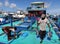 A fisherman carrying fish from a boat to the city market.