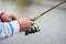 A fisherman catches a fish. Hands of a fisherman with a spinning rod in hand closeup. Spin fishing reel