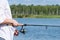 Fisherman catches fish on the lake on spinning close-up, background