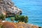 Fisherman catches fish on the rock shores of the Mediterranean.