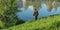 A fisherman catches fish, stands by the lake. Summer, sunny weather, lake