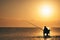 Fisherman catches fish at sunrise in mediterranean sea