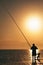Fisherman catches fish at sunrise in mediterranean sea