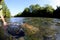 Fisherman catching brown trout from river