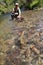 Fisherman catching trout in a crystal clear water