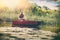 Fisherman caught a fish. A man in a fishing boat in lake.