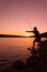 Fisherman Checking Lure at Sunset