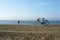 Fisherman and classic bike on sandy beach
