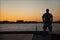 Fisherman on the dock at the river during sunset